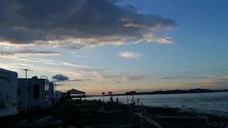 RV sites at Beachcomber RV Park during a dramatic shoreline sunset